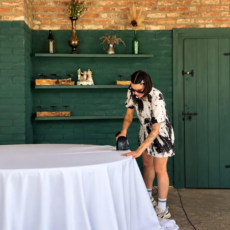 At an outdoor venue wedding planner Elina checks the setup of the wedding arch and floral decoration